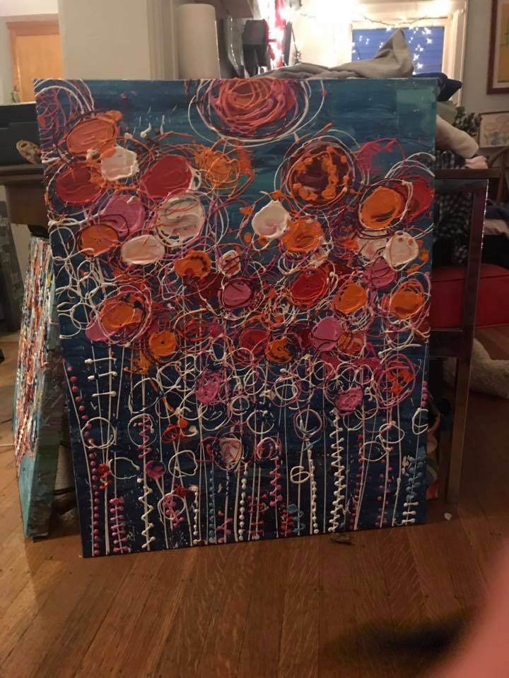 A deep blue painting covered in coral, orange, and pink blooms, with coiled white line work and dotted stems running down the canvas.