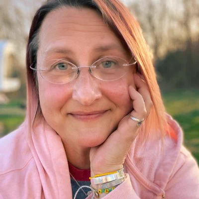Jennifer Paulette Day smiling outdoors in a pink jacket, from the portrait she shared on her public Phishngal profile.